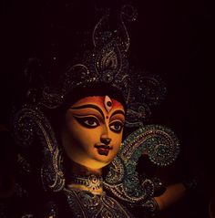 a close up of a person wearing a costume and headdress in the dark