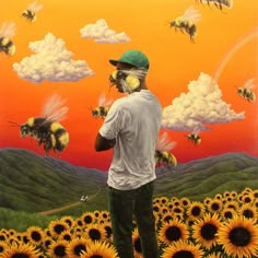 a man standing on top of a field of sunflowers with bees flying over him