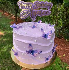 a birthday cake with purple frosting and butterflies on it