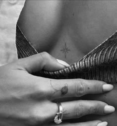 a woman's hand holding onto her belly with a cross tattoo on the side