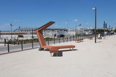 an orange bench sitting in the middle of a parking lot next to a light pole