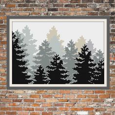 a cross stitch pattern with trees in the background on a brick wall, framed by a black and white frame