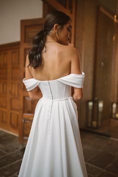 a woman in a white wedding dress looking back