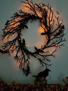 a wreath made out of branches with lights on it and a bird perched on the branch