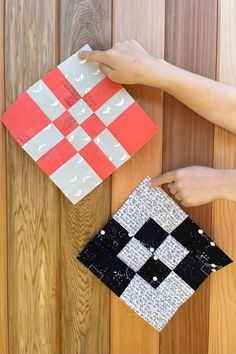 two pieces of fabric are hanging on a wooden wall, one has a checkerboard design