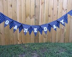 a banner that says game day hanging on a fence in front of a wooden fence