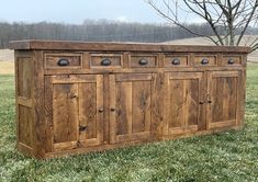 a large wooden cabinet sitting in the grass