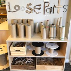 several different types of thread and spools on a shelf in a craft room