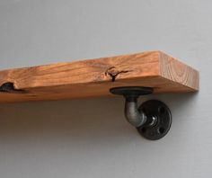 a wooden shelf with two pipe holders on the top and an iron fitting hole in the middle