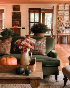 a living room filled with lots of furniture and flowers on top of a coffee table