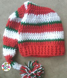 a red and white knitted hat sitting on top of a floor