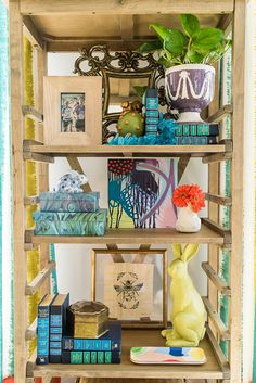 a wooden shelf filled with books and pictures