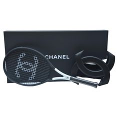 Chanel black tennis racket with leather CC cover Cover has chains in the back to carry the racket ,it has 2 snap closure on the side to slide and hold racket in.Huge box, dust-bag ,tags, racket and cover included. Carry Like a Backpack or on One Shoulder. Chain length is about 29" and cover CC lather piece in the middle is about 11". FINAL SALE. Chanel Tennis Bag, Chanel Tennis Racket, Chanel Tennis, Chanel Sport, Tennis Racket Bag, Accessories Website, Tennis Bag, Tennis Skirts, Luxury Lifestyle Dreams