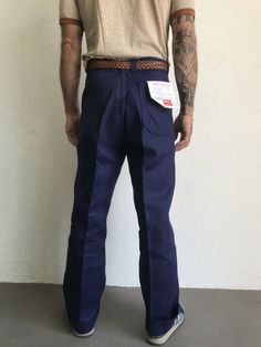 "French blue work trousers - Macober Made in France 1970s High waist pants in indigo blue sanforized cotton . Straight cut with crease. 5 button closure. Bakelite buttons. All originals. 2 side pockets, 1 buttoned back pocket. 5 belt loops. In perfet condition. New item. Deadstock With original cardbord label . Never washed. Label size: 42/12 The model usually wears a size M (40/42) and measurs 175cm - 68,8,\" Measurements (flat): Waist: 42cm - 16,5\" Hips: 54cm - 21,2\" Crotch: 33cm - 12,9\" fr Retro Cotton Jeans For Work, Retro Blue Straight Leg Pants, Cotton Work Pants With Belt Loops, Indigo Cotton Bottoms With Belt Loops, Indigo Straight Leg Pants With Belt Loops, Indigo Workwear Bottoms With Belt Loops, Classic Indigo Cotton Pants, Retro Blue Jeans For Work, Navy Cotton Straight Leg Work Pants