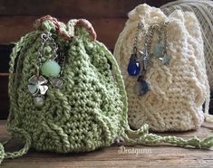 three crocheted bags sitting on top of a wooden table