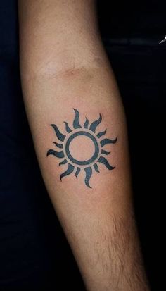 a man with a sun tattoo on his arm