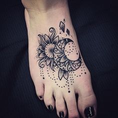 a woman's foot with a sun and moon tattoo on it