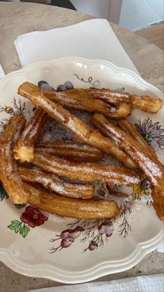 powdered sugar covered churros on a plate