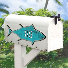 a mailbox with a fish painted on it's side and the number 89