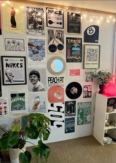 a room with posters and plants on the wall