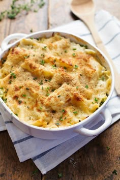 a casserole dish with cheese and parmesan bread in it on a wooden table