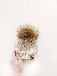 Keep your little one cozy and stylish in the cold weather! Made with extra chunky yarn to keep you warm all winter long! Solid coloured toques can be made in 20 different colours. Faux fur pompom is included in price. Pom does NOT need to be purchased separately. To view pompom options, select Pom section in the shop  This item is made to order. Please review shop announcement for current turnaround time. Price is for ONE item only.  Care: Handwash, roll in a towel to remove excess water and lay flat to dry.  All items are from a smoke-free and pet-free home. LOCAL PICKUP AVAILABLE- If you live in the Ottawa area and prefer to pickup and save the shipping costs, enter code PICKUP at checkout (please note that pickup is in East Ottawa Knit Toque, Hat Knit, Knit Hats, How Big Is Baby, Pom Pom Hat, Chunky Yarn, Loom Knitting, Knit Hat, Winter Wear