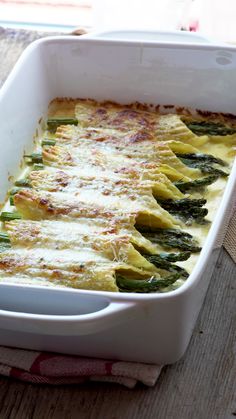 asparagus and cheese casserole in a white dish on a wooden table