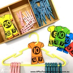 an open box with clothes pins and paper clips in it next to some cut outs