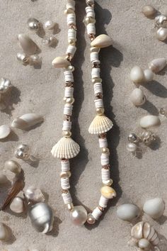 several seashells and pearls are on the sand