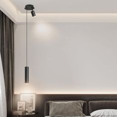 a bed with pillows and blankets in a bedroom next to a wall mounted light fixture