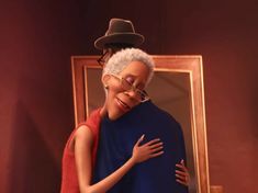 an older woman hugging a younger man in front of a mirror