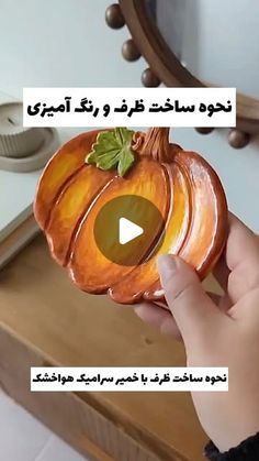 someone is holding a pumpkin shaped bowl in their hand