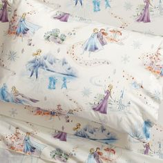 the bedding is made up with disney princesses and snowflakes on it