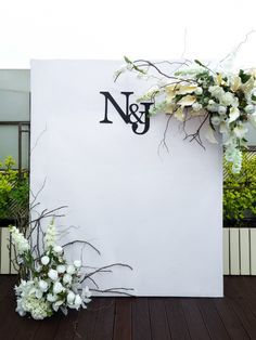 a sign that has flowers on it and the letter n is next to some plants