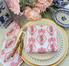 a table topped with pink flowers and plates