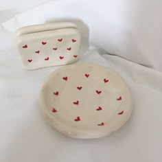 two white dishes with red hearts on them