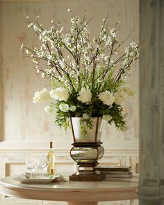 a vase filled with white flowers sitting on top of a table