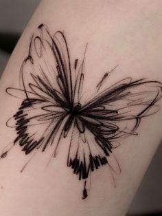 a black and white butterfly tattoo on the arm