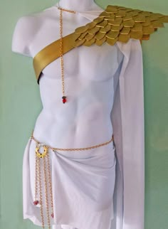 a white mannequin with gold chains and wings on it