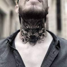 a man with a tattoo on his neck and chest is looking up at the sky