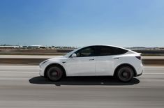 a white electric car driving down the road