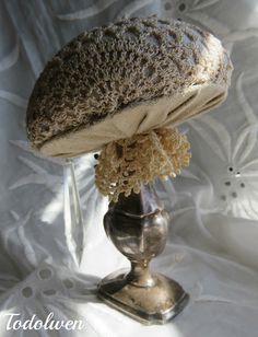 a silver vase with flowers in it sitting on a white cloth covered tablecloth,