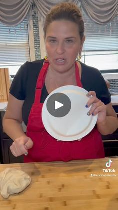 a woman in an apron holding a white plate