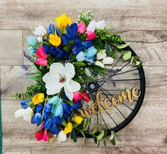 a bicycle wheel decorated with flowers and the words welcome