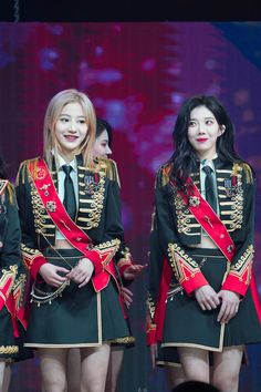 three women in uniform standing on stage