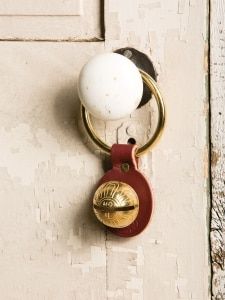 a door handle with a white ball on it and a red leather keychain