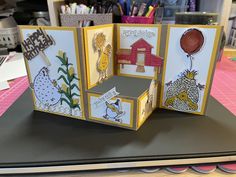 three cards with different designs on them sitting on top of a table in front of some crafting supplies