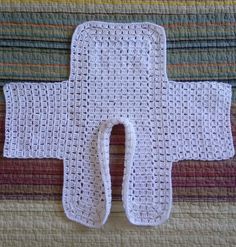 a crocheted white object sitting on top of a bed