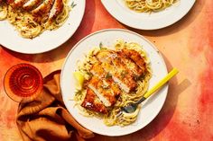 three plates of pasta with chicken and sauce on the side, next to a glass of wine