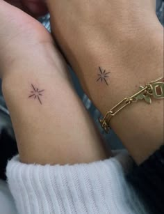 two people with matching tattoos on their arms, one is holding the other's hand